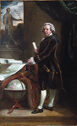 Formal portrait of a middle-aged gentleman in eighteenth-century attire, stands next to a table with maps, looking at the viewer.