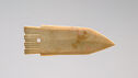 A broad, flat dagger blade made of ivory colored jade