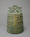 A slightly tapering cylinder which is decorated and topped by two symmetrical creatures