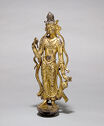 A gilt bronze sculpture of a person standing with flowing ribbons around them.