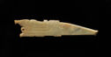 A flat jade sculpture that is long in shape with the left side being wide with rounded engraved details and the right side coming to a narrow, blunt edge. It is colored light yellow-green.