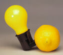 The socket of a light bulb affixed to a lemon, and accompanying square wooden box