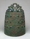 A wide cylinder which is decorated and topped by two symmetrical creatures
