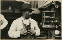 A black and white photograph of a man wearing an apron.