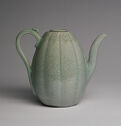A light green pitcher with a slender handle and a tall spout
