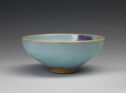 A curved teal bowl with a spot of purple on the inside.