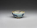 A small pale teal bowl with spots of purple glaze. 