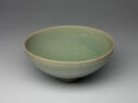 A pale green bowl with cracks in the glaze throughout. 