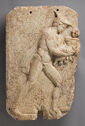 A rectangular marble relief portrays Hermes striding to the right in profile, holding the infant Dionysos in front of him.