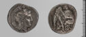 Both sides of an irregularly shaped silver-gray coin with relief decoration on each side.