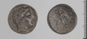 Both sides of an irregularly shaped silver-gray coin with relief decoration on each side.　