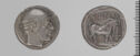 Both sides of an irregularly shaped silver gray coin with relief decoration on each side.