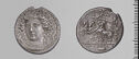 Both sides of an irregularly shaped silver-gray coin with relief decoration on each side.