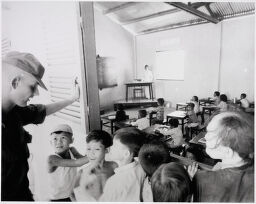 Untitled (Soldier Talking To Children Outside School Room, Vietnam)