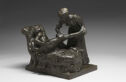 Bronze sculpture of a masseuse massaging the leg of a woman draped across a lounge. 