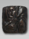 A relief plaque of a woman’s head resting against the chest of a larger unknown figure.