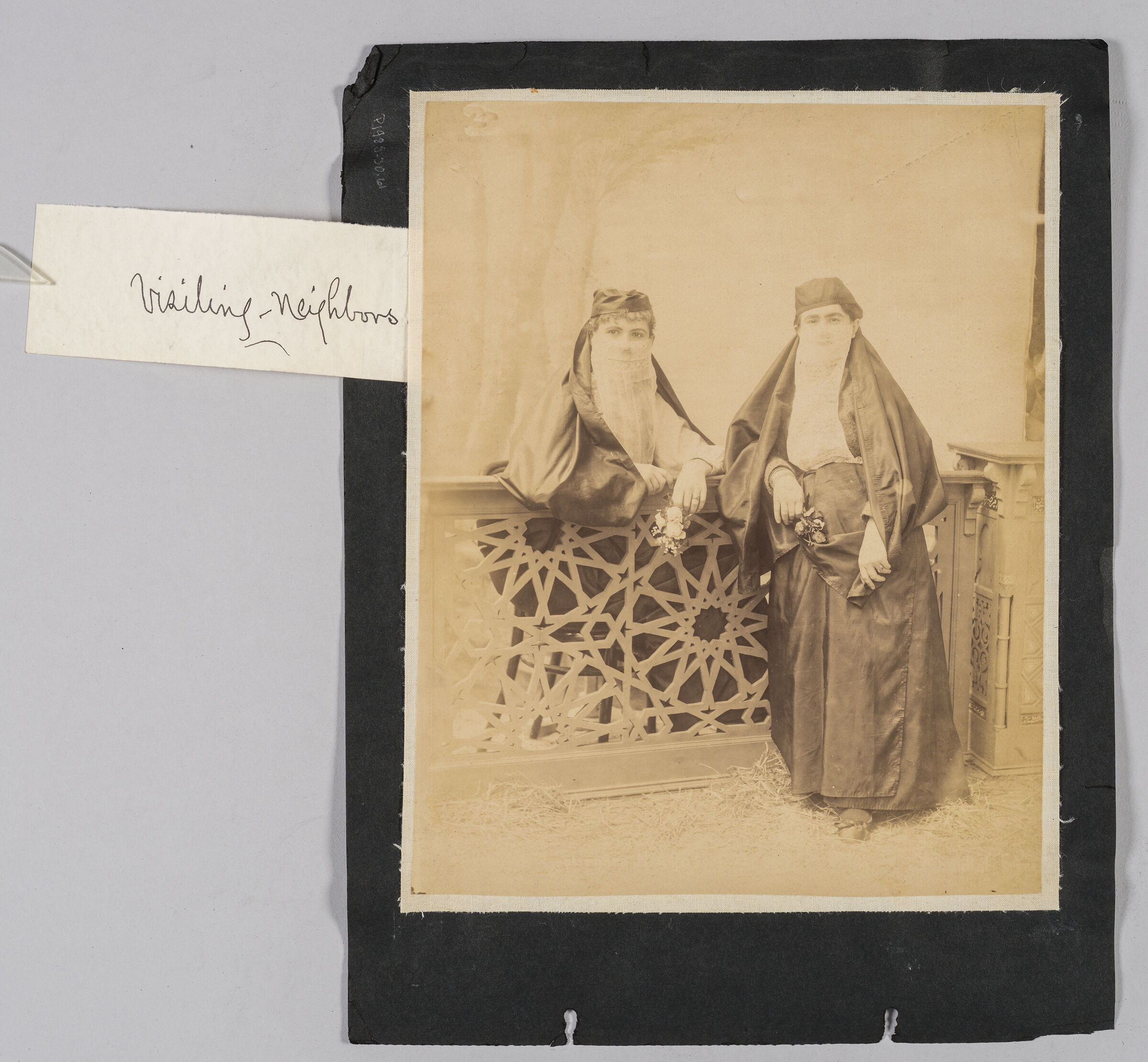 Untitled (Two Women In Traditional Dress With White Veils Leaning On Decorative Balustrade, Both Holding Flowers)