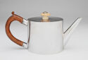 A silver teapot with a wooden handle.