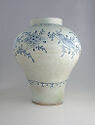 A white porcelain jar with blue painted birds and floral decor