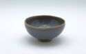 A curved pale teal bowl with a bare foot.
