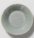 A wide, circular dish with a floral design in low relief