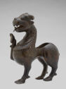Brown figure of a lion with an upturned paw and a hollow space in the back