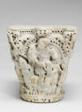 Top of a marble column carved with images of religious figures