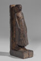 
Dark wood statuette of a man wearing a long kilt.