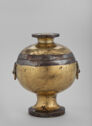 Round golden container on pedestal with lid
