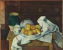 Still life of a bowl of fruit sits on a wooden table with three ceramic containers of various sizes.