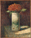Still life of a tall cylindrical vase on a table holding a cluster of flowers as the sunlight hits it. 　