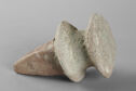 A terracotta object in the shape of a large, thick spike. The top edge is flat and flares outward. There is another flared edge just below that. It is light grey and brown in color.