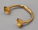 A golden semicircular band with cone shaped cups at either end.
