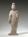 An earthenware figure of a standing man wearing long, draped robes. His face is plump and his hair sits on top of his head in a round bun.