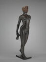 A three-dimensional bronze sculpture of a standing nude woman holding a rolled towel behind herself.