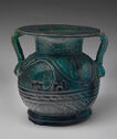 Opaque blue-green glazed faience amphora with two handles, short neck, wide flat lip, and etched pattern decorations.