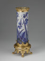 Cylindrical vase with blue-and-white botanical design and gold accents