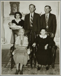 Untitled (Six Generations: Three Women, Two Men, And Baby In Living Room In Front Of Clock)