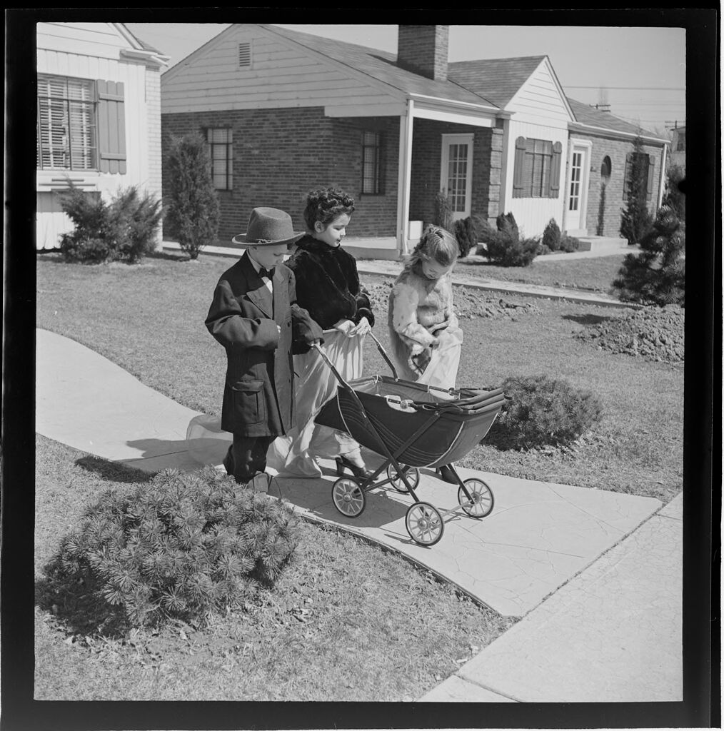 Untitled (Children Playing Dress-Up And Walking Baby Carraige On Sidewalk)