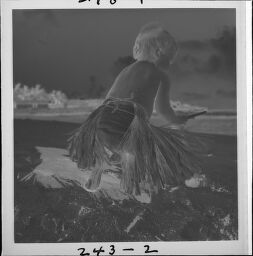 Untitled (Small Child On Beach In Grass Skirt And Lei)
