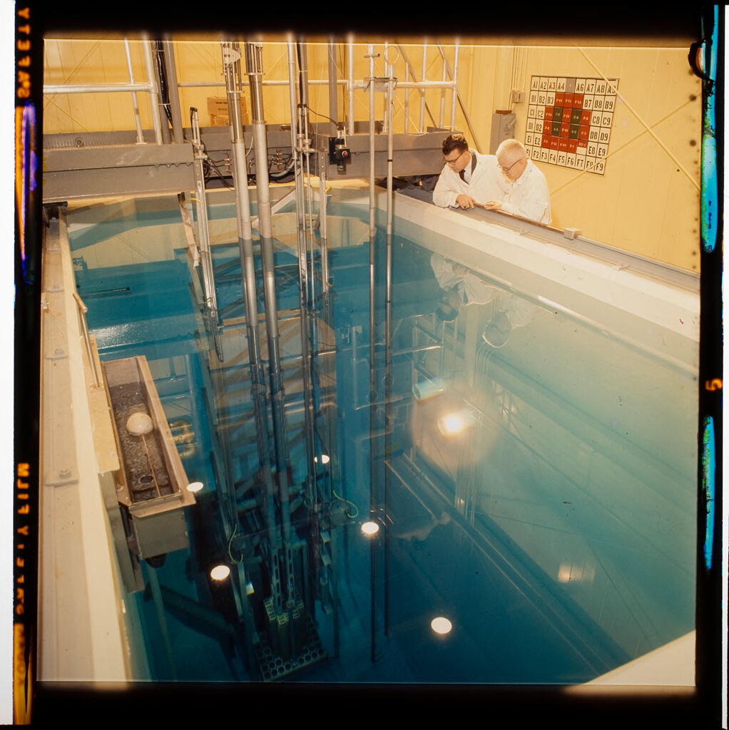 Untitled (Scientists Looking Into Pool Of Water At Research Facility)
