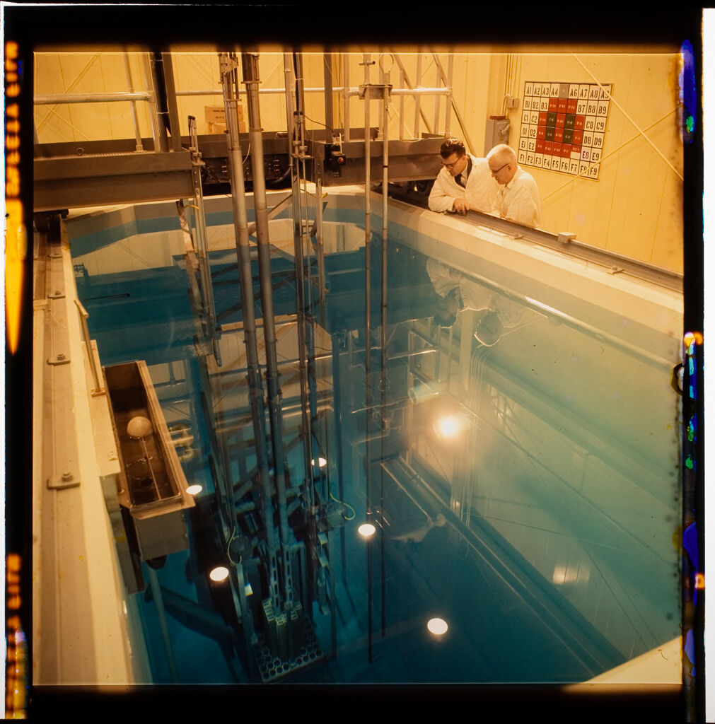 Untitled (Scientists Looking Into Pool Of Water At Research Facility)