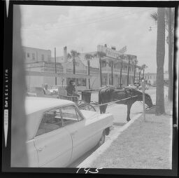 Untitled (Horse Drawn Carriage Through Small Beach Town, Car In Foreground)