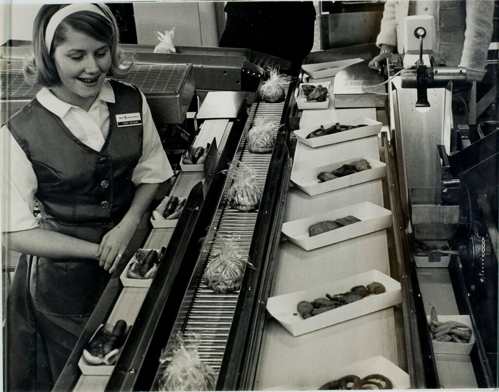World's First Fully Automated Restaurant (Third Of Eight): Judy Reimann Looks On With Delight As Converors Move The Food Items From The Machines Of The Amfare System To The Assembly Area.  From Left To Right Are, Hot Dogs, Wrapped Hamburgers, An Assortment Of French Fried Onion Rings, Chicken And Shrimp, And French Fried Potatoes.