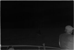 [Man On Ship Deck Looking Out At Sailboat]