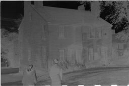 [Unidentified Man And Woman Looking At Clapboard House]