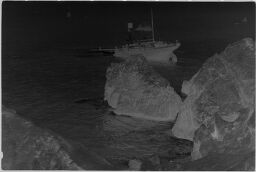 [Rocky Shoreline With Fishing Boat]