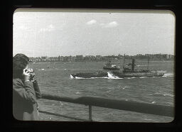 [Woman With Camera On Ship Deck, Looking At Boats]