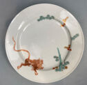 Large white plate, painted details of a tiger near bottom moving towards bamboo that curves along the plate on right.