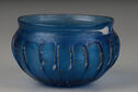 Translucent cobalt blue glass bowl with several irregular white marks, a short concave shoulder and convex, ribbed sides  